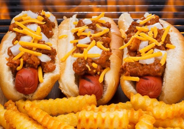 Three chili dogs with cheese and onions, and fries