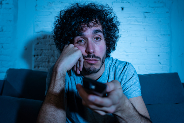 young man bored watching tv