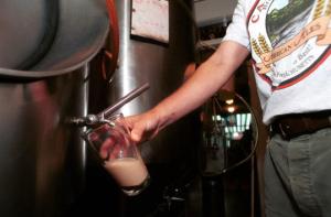 An employee tests beer at Cambridge Brewing Company, one of 64 Massachusetts breweries highlighted.