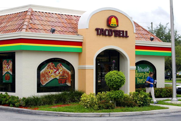 A Taco Bell restaurant, c. 2002, displaying discontinued Taco Bell items on the window.