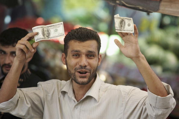 What's a Thousandaire? Maybe this guy. A Palestinian government employee holds cash that he received as part of his salary