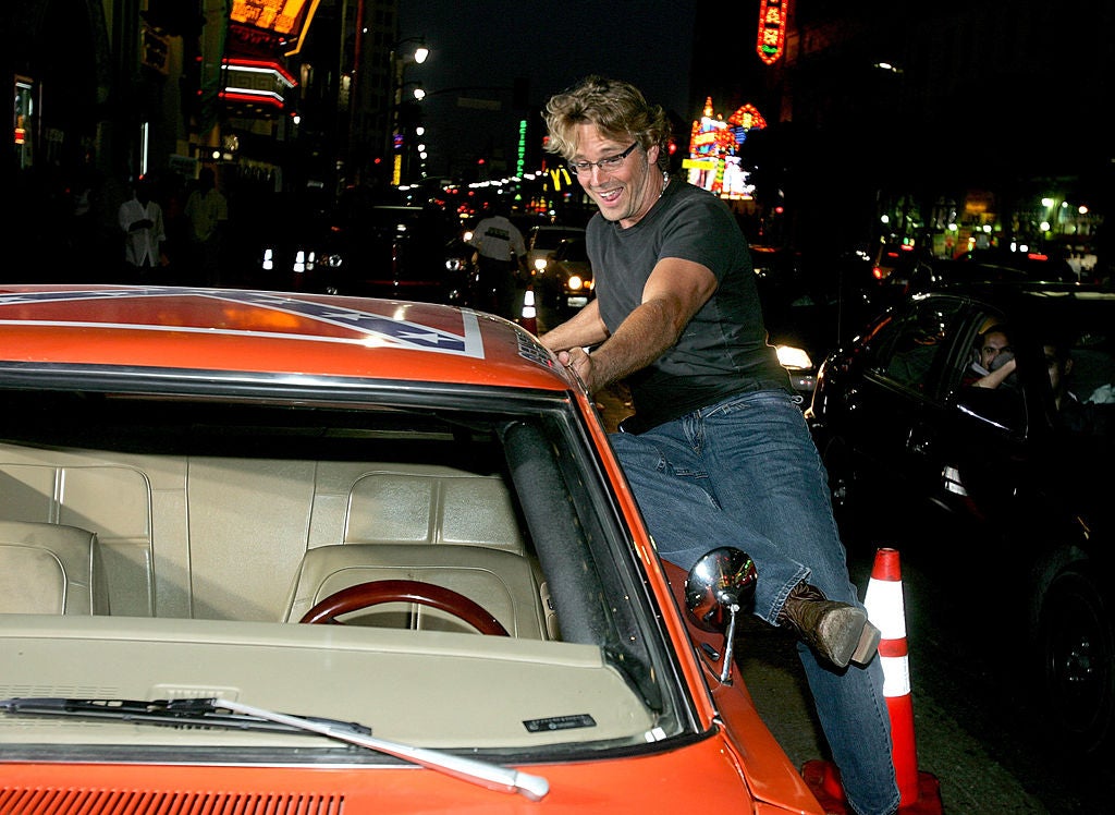 Actor John Schneider jumping into the General Lee.